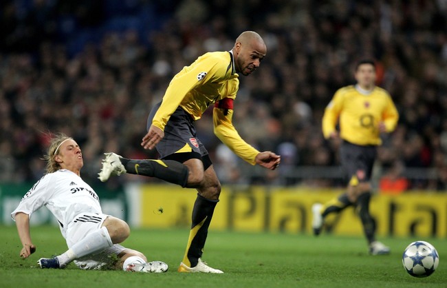 MADRID, SPAIN - FEBRUARY 21:  Thierry Henry of Arsenal shakes off the challenge of Jose Maria Guti of Madrid on his way to scoring the only goal of the game during the UEFA Champions League Round of 16, First Leg match between Real Madrid and Arsenal at the Santiago Bernabeu Stadium on February 21, 2006 in Madrid, Spain.  (Photo by Richard Heathcote/Getty Images)