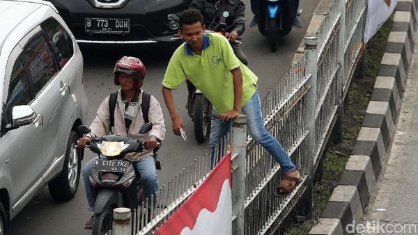 Aksi Nekat Penyeberang Naik Pagar Tinggi di Jatinegara