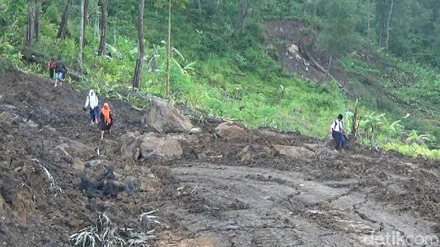 Warga tampak melalui jalan yang amblas di Banjarnegara. 