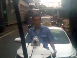 Sopir Taksi Ini Nangkring saat Mobilnya Diderek Dishub
