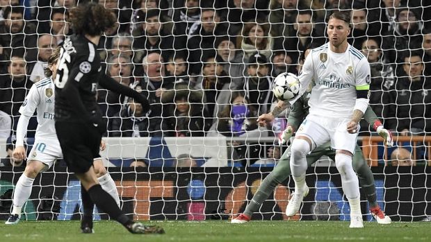 Paris Saint-Germain's French midfielder Adrien Rabiot (L) kicks the ball in front of Real Madrid's Spanish defender Sergio Ramos (R) during the UEFA Champions League round of sixteen first leg football match Real Madrid CF against Paris Saint-Germain (PSG) at the Santiago Bernabeu stadium in Madrid on February 14, 2018.   / AFP PHOTO / GABRIEL BOUYS