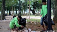 Beberapa petugas langsung membersihkan area taman dari sampah.