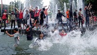 Penampakan sejumlah massa Jakmania yang menceburkan diri ke kolam air mancur di Balai Kota, Jakarta, Minggu (18/2/2018).