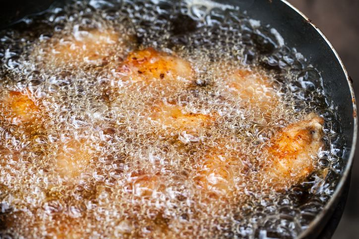 Close up image of cooking chicken in deep fry