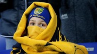 Bukan cuma pemain Roma yang dicengkeram rasa dingin. Fans di stadion pun harus membalut diri dengan atribut tebal demi menjaga tubuh tetap hangat. (Foto: Gleb Garanich/Reuters)