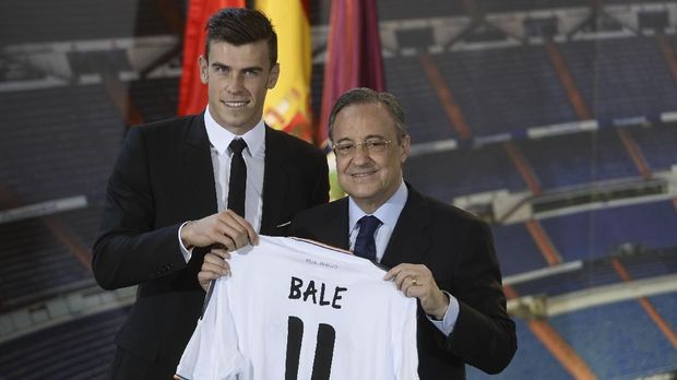 New Welsh striker Gareth Bale of Real Madrid (L) poses with his new jersey next to Real Madrid's President Florentino Perez during his presentation at the Santiago Bernabeu stadium in Madrid on September 2, 2013. Bale was unveiled as a Real Madrid player today after his prolonged transfer from Tottenham Hotspur was finally completed for an unconfirmed world record fee late September 1. The Welshman has agreed a six-year deal believed to be worth 10 million euros net a year and will be presented to the media and the club's fans after undergoing a medical in the Spanish capital. AFP PHOTO/ PIERRE-PHILIPPE MARCOU / AFP PHOTO / PIERRE-PHILIPPE MARCOU