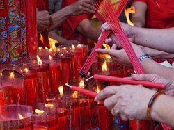 Menyalakan hio dan lilin untuk sembayang
