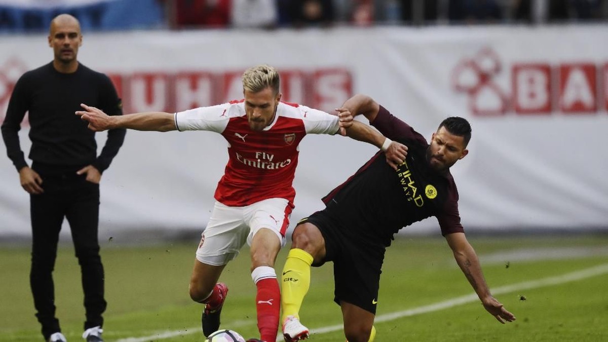 Aaron Ramsey berduel dengan sriker Manchester City, Sergio Aguero, di laga pramusim. (Foto: Nils Petter Nilsson/Ombrello/Getty Images)