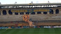 Fans Brondby membentangkan spanduk berbentuk kapal viking pada pertandingan kandang. (Istimewa)