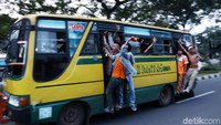 Mereka meneriakkan yel-yel dari atas bus kota.