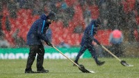 Seiring berjalannya laga, hujan salju yang turun makin lebat. Para petugas pun bekerja keras membersihkan lapangan dari salju saat half time. Foto: Matthew Childs/Action Images via Reuters