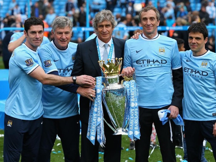 MANCHESTER, ENGLAND - MAY 11:  (L-R) Manchester City Goalkeeping Coach Xabier Mancisidor, Joint Assistant Manager Brian Kidd, Manager Manuel Pellegrini, Joint Assistant Manager Ruben Cousillas and Fitness Coach Jose Cabello pose with the trophy after the Barclays Premier League match between Manchester City and West Ham United at the Etihad Stadium on May 11, 2014 in Manchester, England.  (Photo by Alex Livesey/Getty Images)