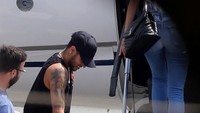 Neymar tampak memakai kruk saat hendak memasuki pesawat yang membawanya. (Paulo Whitaker/Reuters)