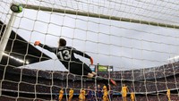 Jari-jari tangan kirinya sempat menyentuh bola, tapi tak cukup untuk menghentikan lajunya atau menepisnya ke luar lapangan. Barcelona 1-0 Atletico. (Foto: Albert Gea/REUTERS)