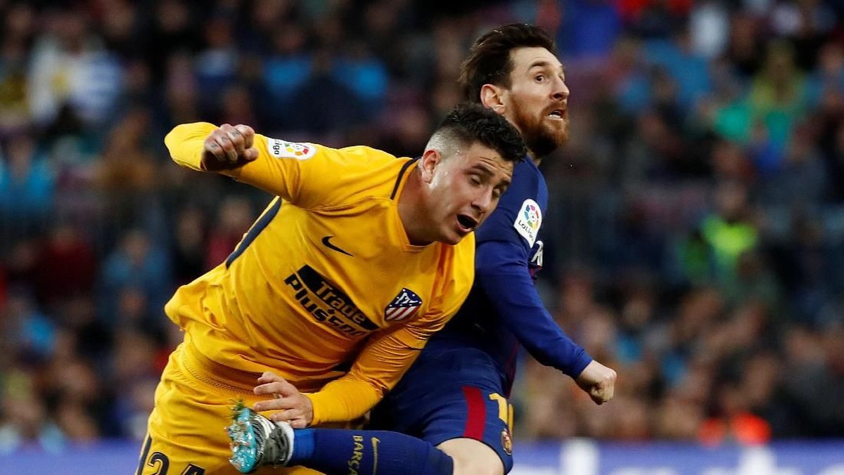 Lionel Messi berduel dengan bek Atletico Madrid, Jose Gimenez. (Foto: Juan Medina/REUTERS)
