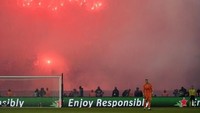 Ultras Paris menyalakan flare pada laga PSG vs Madrid. Tribune belakang gawang menjadi titiknya. (Foto: Pierre-Philippe MarcouAFP)