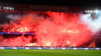 Fans PSG menyalakan flare dalam jumlah besar di babak kedua. Asap dari flare tersebut masuk ke arena permainan dan memaksa wasit sejenak menghentikan laga. Foto: Matthias Hangst/Getty Images
