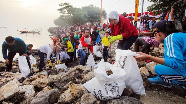 Wali Kota Surabaya Tri Rismaharini (kedua kanan) bersama sejumlah pelajar memunguti sampah yang berserakan di pinggiran pantai di dekat Jembatan Suramadu, Surabaya, Jawa Timur, Sabtu (24/2). Kegiatan yang diikuti ribuan pelajar, pegawai Pemkot Surabaya, TNI dan Polri itu dalam rangka Hari Peduli Sampah Nasional. ANTARA FOTO/Didik Suhartono/ama/18