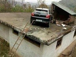 Kecelakaan, Buat Mobil Ini Tersangkut di Atap Rumah