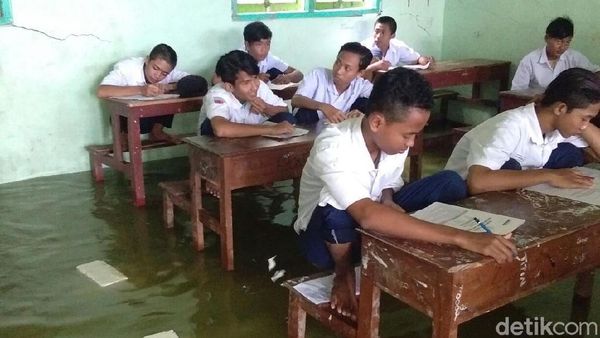 Foto: Siswa MTs Nangkring di Kursi saat Ujian karena Banjir