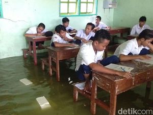 Foto: Siswa MTs Nangkring di Kursi saat Ujian karena Banjir