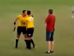 Wasit bernama Gabriel Murta menenteng pistol ke lapangan karena kesal dipukul pemain dalam laga Brumadinho vs Amantes de Bola, klub amatir di Brasil. Ia mengacungkan pistol sebelum diamankan rekannya. Murta dihukum dan diperiksa kejiwaannya usai insiden itu. (Foto: Screenshots Youtube)