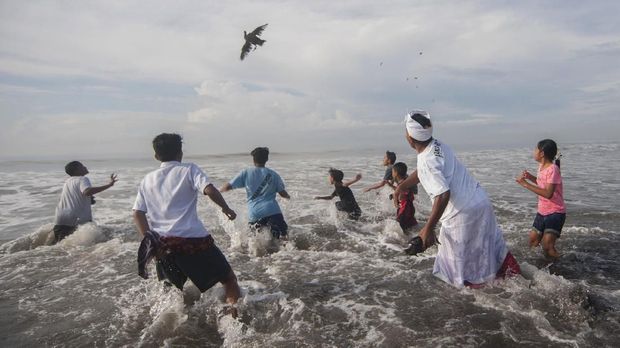 Umat Hindu melempar hewan kurban ke laut pada puncak ritual Melasti menjelang Hari Raya Nyepi Tahun Saka 1940 di Pantai Purnama, Gianyar, Bali, Rabu (14/3). Ritual tahunan tersebut berlangsung selama tiga hari secara bergantian yang sebagian besar digelar di pantai, danau dan sungai di seluruh Bali untuk penyucian alam sehingga Hari Raya Nyepi dapat berjalan hening serta damai. ANTARA FOTO/Nyoman Budhiana/ama/18.