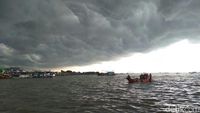 Awan Gelap Payungi Petugas Bersihkan Lautan Sampah di Teluk Jakarta