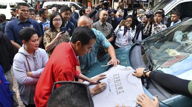 Presiden Joko Widodo menandatangani kaos untuk 'Jokowi' di Selandia Baru.