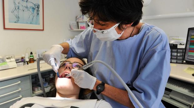 A dentist treats a patient April 13, 2017 in Quimper, western France.  / AFP PHOTO / FRED TANNEAU