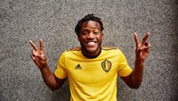 Jersey tandang Belgia mempunyai warna dasar kuning. Di pundaknya, ada toga garis hitam-merah-hitam. Michy Batshuayi yang memamerkannya. (Foto: dok. Adidas)