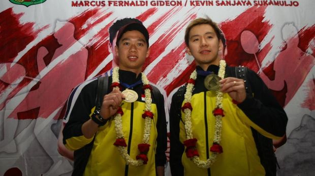 Kevin Sanjaya (kiri) dan Marcus Gideon (kanan) menunjukkan medali kemenangan di All England, di bandara Soekarno Hatta, Tangerang, Banten, Selasa (20/3).