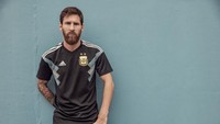 Lionel Messi yang memamerkan jersey tandang Argentina. Warna dasarnya biru gelap dengan aksen tiga garis di pundak dan putih-biru muda di dada. (Foto: dok. Adidas)