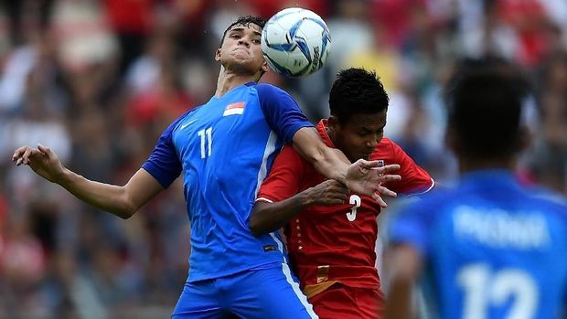 Ikhsan Fandi Ahmad (L) of Singapore fights for the ball with Htike Htike Aung (C) of Myanmar during their men's football Group A round match at the 29th Southeast Asian Games (SEA Games) at Selayang Stadium, outside Kuala Lumpur, on August 14, 2017. / AFP PHOTO / MANAN VATSYAYANA