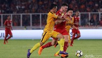 Marko Simic berusaha melewati pengawalan ketat dua pemain Bhayangkara FC.