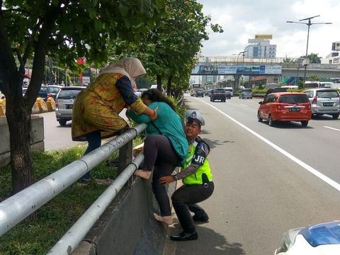 Polisi bantu emak-emak manjat.