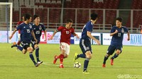 Egy Maulana berusaha melewati kepungan para pemain Jepang.