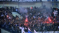 Pendukung Persib menyalakan kembang api.