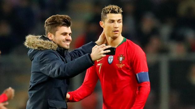 Seorang penonton yang masuk ke dalam lapangan saat pertandingan Portugal vs Belanda berfoto dengan Cristiano Ronaldo.