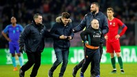 Pada prosesnya, para penyusup lapangan yang nekat ini digelandang keluar dari lapangan agar pertandingan bisa dilanjutkan. Saat itu Portugal tertinggal 0-3 dari Belanda. (Foto: Denis Balibouse/Reuters)