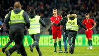 Sosok Cristiano Ronaldo adalah magnet. Di tengah-tengah laga Portugal lawan Belanda ini pun fansnya sampai nekat mengambil risiko untuk mendekatinya. (Foto: Denis Balibouse/Reuters)