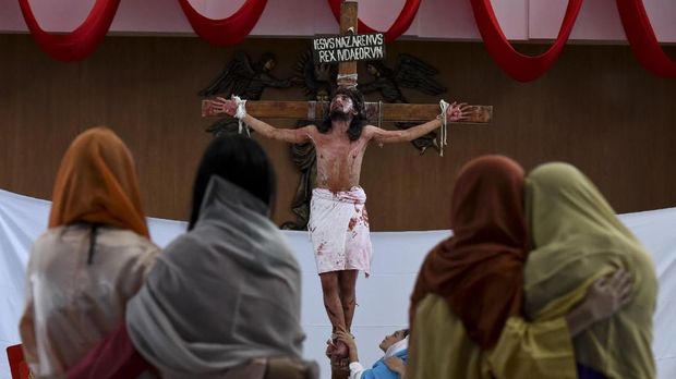 Umat  Kristiani memperagakan drama penyaliban Yesus di Gereja Santa Maria Regina di Bintaro, Tangerang Selatan, Banten, Jumat (30/3). Drama yang mengisahkan kesengsaraan saat penyaliban Yesus itu untuk memperingati wafatnya Yesus atau Isa Almasih. ANTARA FOTO/Hafidz Mubarak A/ama/18