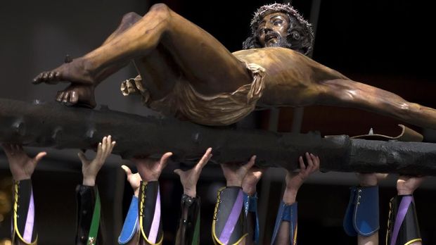 Spanish legionnaires carry a crucifix figure depicting 'El Cristo de la Buena Muerte' (Christ of the Good Death) to Santo Domingo de Guzman church during the 'Cristo de Mena' Holy Week procession on March 29, 2018 in Malaga, southern Spain. Christian believers around the world mark the Holy Week of Easter in celebration of the crucifixion and resurrection of Jesus Christ. / AFP PHOTO / Jorge Guerrero