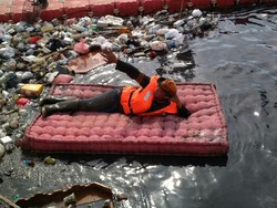 Gaya Petugas Badan Air Tiduran di Kasur yang Dibuang ke Kali