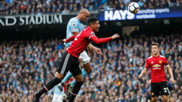 Vincent Kompany memenangi duel udara melawan Raheem Sterling.