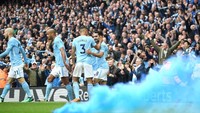 Mau perbandingan warna biru di rambut Pogba dengan birunya City? Beginilah kira-kira. Asap biru itu menjadi bagian dari pemandangan di lapangan usai Ilkay Guendogan mencetak gol kedua The Citizens. (Foto: Michael Regan/Getty Images)