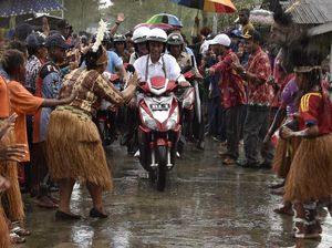 Foto: Jokowi-Iriana Boncengan Motor Menembus Hujan di Asmat