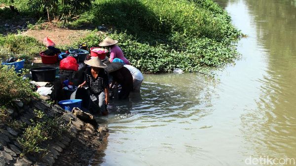 Mencuci Pakaian di Sungai Keruh