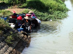 Mencuci Pakaian di Sungai Keruh