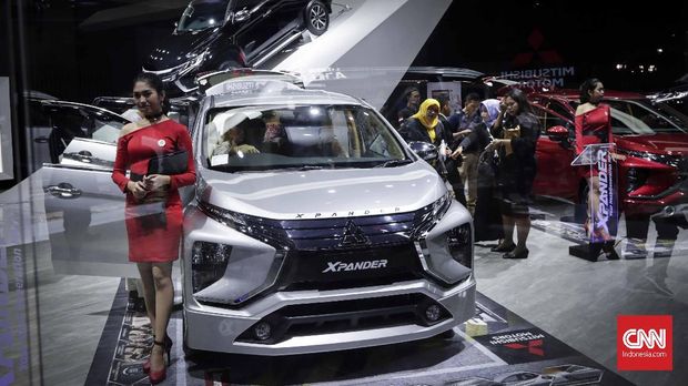 Salah satu penjual Mitsubishi berdiri di samping Xpander di acara IIMS 2018